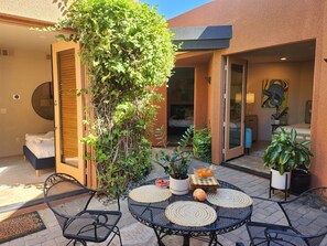 A patio with outdoor seating, a bed, and a view of the interior. - Stunning Villa in the Palmilla Estates. 4-bedroom house with new furniture. (La Quinta)