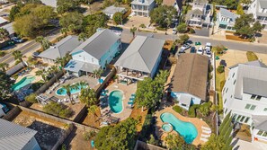 Um bairro residencial com várias casas, uma piscina e um quintal cercado.
