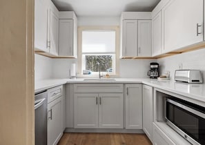 A modern kitchen with white cabinets, a built-in oven, a coffee maker, and a toaster. - Lone Star-New! Sleep 8 in Seal Harbor! (Mount Desert)