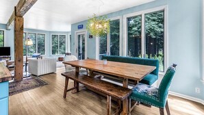 Comedor con mesa de madera, bancos y una silla tapizada en color aguamarina.