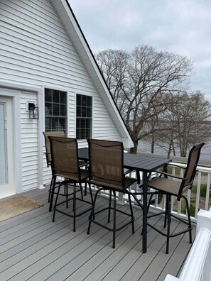 A deck with a table and chairs, overlooking a body of water. - The Cove on Newbury Neck (Surry)