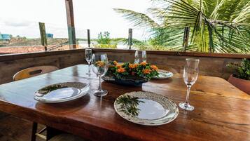 A wooden table with plates, glasses, and a flower centerpiece.