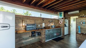 A modern kitchen with a built-in oven, a coffee machine, and a sink. - Pousada Feliz Boipeba Apartamentos (Cairu)