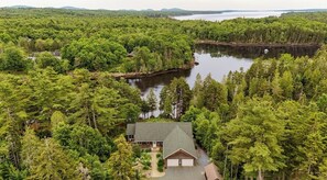 A house surrounded by dense forest and a lake. - Moon River Retreat - Riverfront! (Ellsworth)