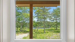A window with a view of a forest and a body of water. - Shoreline Solace - Waterfront! Close to Acadia! (Ellsworth)