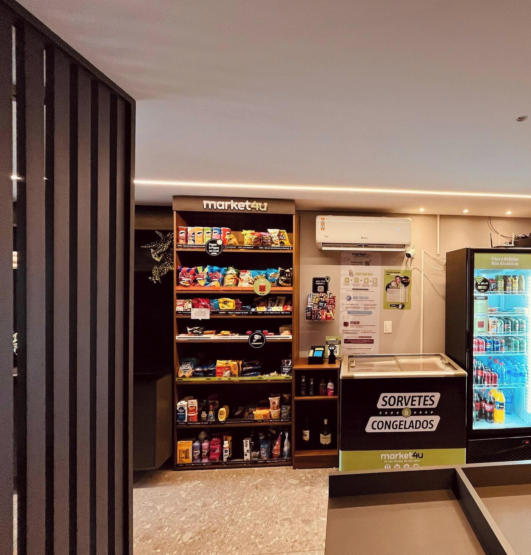 A market stall with snacks and a refrigerated display of beverages.
