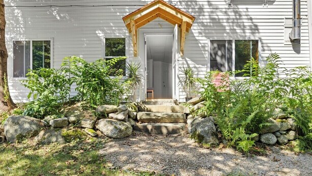 A white house with a wooden front porch, a stone staircase, and a gravel driveway. - Summit Sanctuary – Minutes to Downtown Blue Hill! (Blue Hill)