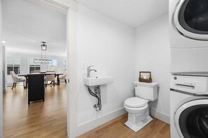 Une salle de bain moderne équipée de toilettes, d’un lavabo et d’un lave-linge.