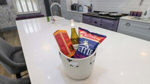 Una cucina con un piano di lavoro bianco, un lavello, un fornello e pensili.