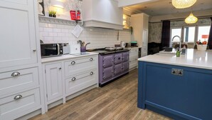 Una cucina moderna con mobili bianchi, un piano cottura viola e un'isola blu.