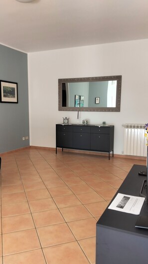 A room with a tiled floor, a black cabinet, a large mirror, and a radiator. - 130 sqm apartment with a balcony that allows you to relax with the sea in your eyes (Santa Flavia)