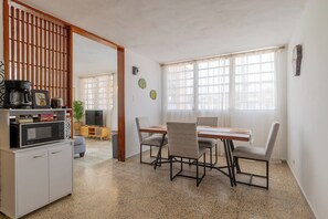 A dining area with a table, chairs, a microwave, a cabinet, and a plant. - Casa de Papi in  Luquillo with cool AC breeze (luquillo)