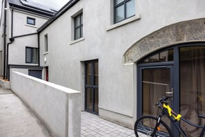 A building with a concrete facade, a bicycle parked outside, and a door with a glass panel. - Luxury Westport Studio | Premium Shower + WiFi (Westport)