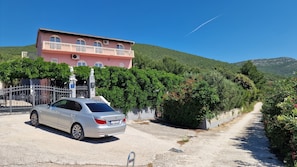 Ein Gebäude mit rosafarbenem Mauerwerk, einem verschlossenen Eingang und einem geparkten Auto davor.