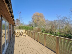 A wooden deck with a table and chairs, surrounded by a wooden fence and trees. - 4 Southern Place (Liskeard)