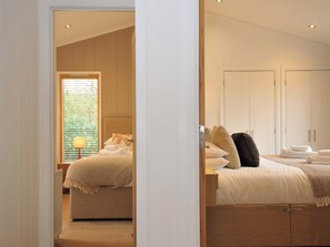 Ein Schlafzimmer mit Bett, Nachttischen, einer Lampe und einem Kleiderschrank.