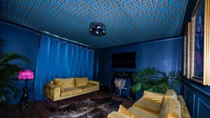 A room with a patterned ceiling, a yellow sofa, a fur rug, and a fireplace. - Bold boudoir interiors, private patio and steps from the beach (West Sussex)