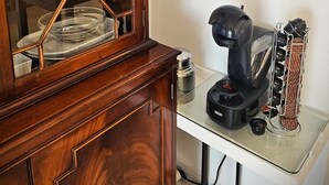 Uma cozinha com um armário de madeira, uma máquina de café e um objeto decorativo na parede.