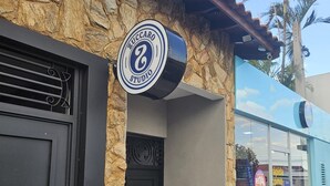 Fachada de edificio con pared de piedra, una puerta negra y un letrero que dice 'Zuccaro Studio'.