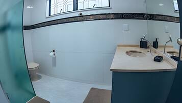 A modern bathroom with a toilet, sink, and shower.