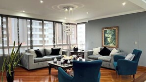 Un salon moderne avec un ensemble de canapés, une table basse et un fauteuil bleu.