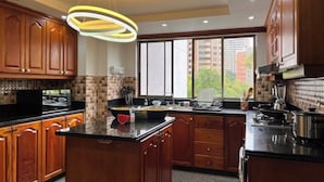 Une cuisine moderne avec des meubles en bois, un îlot central et une grande fenêtre offrant une vue sur les bâtiments.