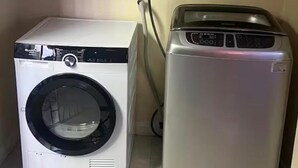 A compact laundry room with a front-loading washer and a top-loading dryer. - Terrific 2-bedroom house with AC in Montego Bay (Montego Bay)