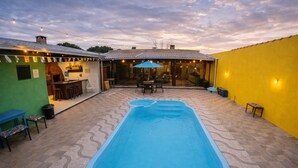 A backyard with a swimming pool, outdoor seating, and a bar area. - Villa Kanindé Bonito (Bonito)