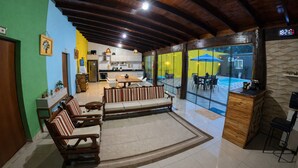 A spacious living area with a wooden ceiling, a dining set, a sofa, and a view of an outdoor swimming pool. - Villa Kanindé Bonito (Bonito)