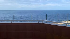Een balkon met uitzicht op zee en lucht.