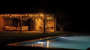 A poolside area with a covered seating area, a dining table, and a pool. - Manoir de charme en Normandie | piscine chauffée à moins de 2h de Paris. (Chambord)