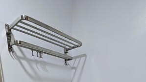 Een badkamer met toilet, wastafel, handdoekrek en spiegel.