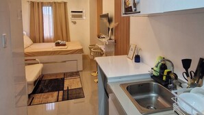 Een moderne keuken met een spoelbak, aanrecht en een eethoek met een stoel en tafel.