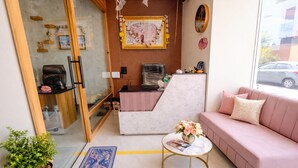 A modern living room with a sofa, a coffee table, and a decorative wall. - Rukkmannie Holiday Inn (Ujjain)
