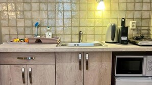 A kitchen with a sink, microwave, and dishwasher. - Emma Apartments - Studio apartment for 1 guest (Hlavní město Praha)