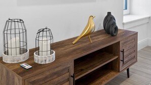 A wooden console table with two wire cage candle holders, a golden bird sculpture, and a black vase. - Luxury 2BR | Free Parking | Harvard/BU | ROKU TV (Boston)