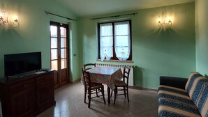 Un espace repas comprenant une table, des chaises, un téléviseur et un canapé.