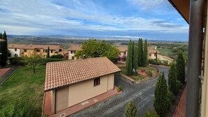 Un quartier résidentiel avec des maisons à étages, un ciel dégagé et une vue lointaine sur la campagne.