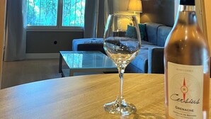 Ein Zimmer mit einem Tisch, einem Weinglas und einer Flasche Côtes de Béziers Wein.