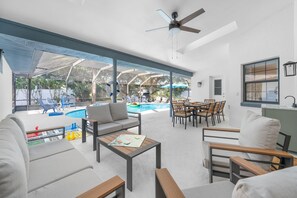 Un espacio exterior moderno con piscina, asientos y ventilador de techo.