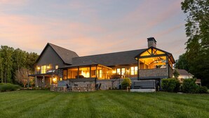 A large, modern house with a stone foundation, a prominent chimney, and a well-lit interior. - Four bedroom  in United States of America, Winchester (Winchester)