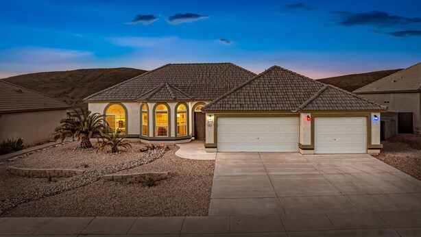 A residential house with a garage, arched windows, and a driveway. - Sunset Pool Home Retreat Sleeps 11 Close to River (Bullhead City)