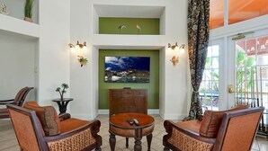 Una sala de estar con chimenea, dos sofás, una mesa de centro y una televisión.