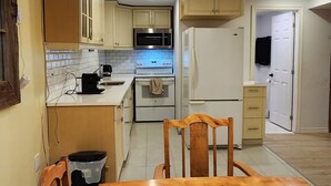Una cucina con mobili bianchi, un tavolo da pranzo in legno e sedie.