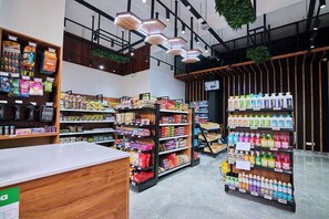 Ein modernes Supermarkt-Interieur mit Holzbögen, einem Empfangsschalter und hängenden Pflanzen.