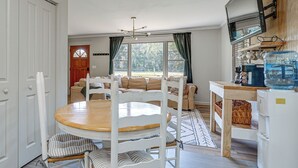 A dining area with a round table, chairs, a sofa, and a kitchen area with a water dispenser. - Deck & Spacious Yard! Wilmington Gem on Half-Acre (Wilmington)