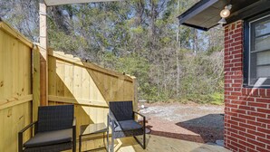 A wooden deck with two chairs, a brick wall, and a window. - Deck & Spacious Yard! Wilmington Gem on Half-Acre (Wilmington)