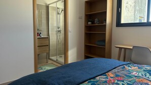 A bedroom with a bed, a shower, a wooden shelf, a desk, and a window. - Casa Del Sol - Quiet with heated pool (Arles)
