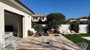 Un patio con mesa, sillas, un altavoz y un televisor.
