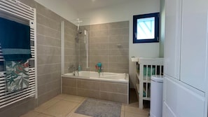 Un baño con ducha, bañera, inodoro y lavamanos.